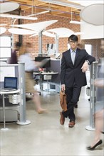 Businessman standing in busy office