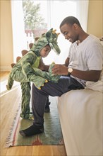 African American father playing with daughter in costume