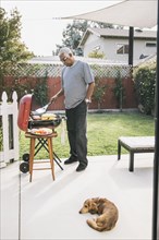 African American man grilling in backyard