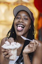 Mixed Race woman showing heart-shape candy on tongue