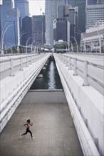 Mixed Race woman running under urban bridge