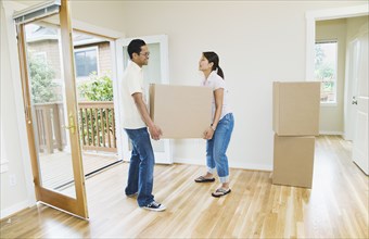 Asian couple moving box in new house