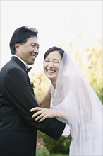 Asian newlyweds laughing