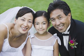 Portrait of Asian newlyweds and daughter