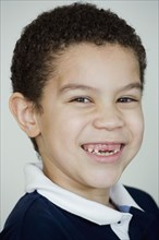Mixed race boy smiling with missing teeth