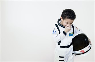 Mixed race boy in astronaut costume