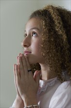 Mixed race girl in nightgown praying