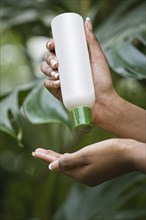 Mixed race woman pouring lotion into hand