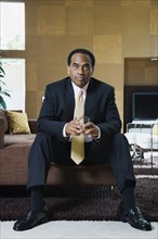 Confident African businessman sitting in modern living room