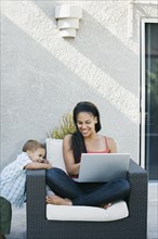 Mother and son looking at laptop on patio