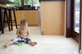 Mixed race boy playing with toys on floor