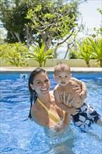 Mother playing with son in swimming pool