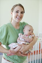 Happy Caucasian mother holding baby daughter