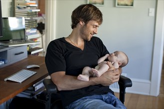 Happy Caucasian father holding baby daughter