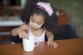 Mixed race girl drinking hot chocolate