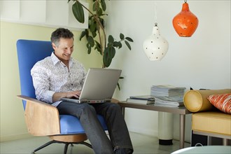 Man typing on laptop in living room