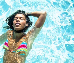 Mixed race woman swimming in swimming pool