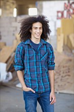 Smiling mixed race teenager with hands in pockets