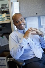 African American businessman sitting in office cubicle