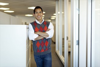 Smiling mixed race businessman standing in office