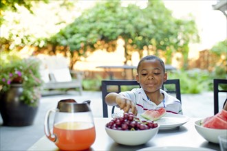 African American boy eating lunch on patio