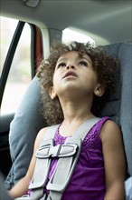 Mixed race girl sitting in car seat
