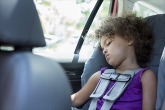 Mixed race girl sleeping in car seat