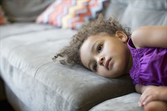 Mixed race girl laying on sofa