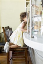 Mixed race girl kneeling at counter