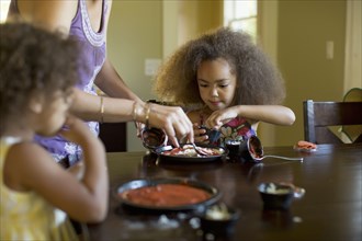 Mixed race girls eating dinner