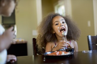 Mixed race girl eating dinner