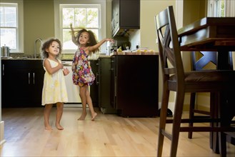Mixed race girls playing in kitchen
