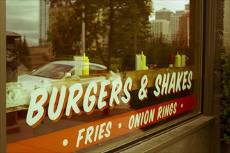 Sign reading "burgers & shakes" on restaurant window