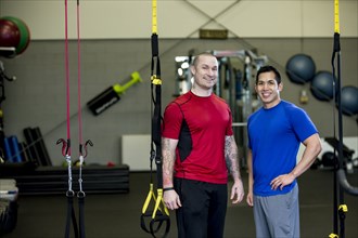 Men smiling together in gym