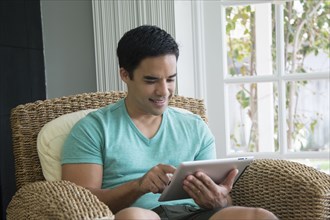 Hispanic man using digital tablet