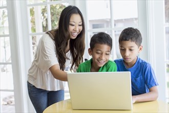 Mother and sons using laptop