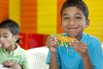 Hispanic boy eating in restaurant