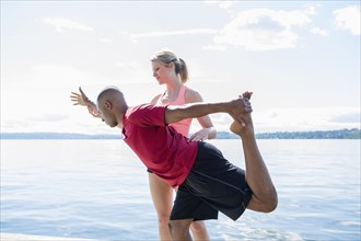 Caucasian man practicing yoga with teacher