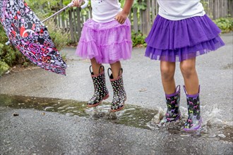 Mixed race girls playing in puddles