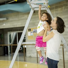 Mother and daughter playing in gym