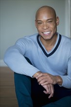 Mixed race man in v-neck sweater