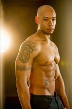 Mixed race man with tattoos on arm