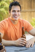 Man drinking beer in backyard