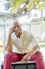 Mixed race man smiling in backyard