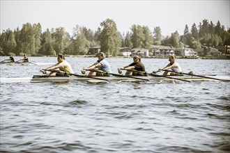 Teenagers rowing scull on lake