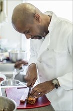 Black chef working in kitchen