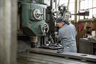 Man using machinery in metal shop