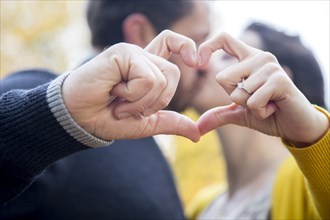Caucasian couple making heart shape with fingers