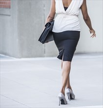 Black businesswoman walking on city street