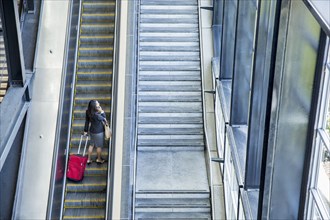 Businesswomen riding escalator